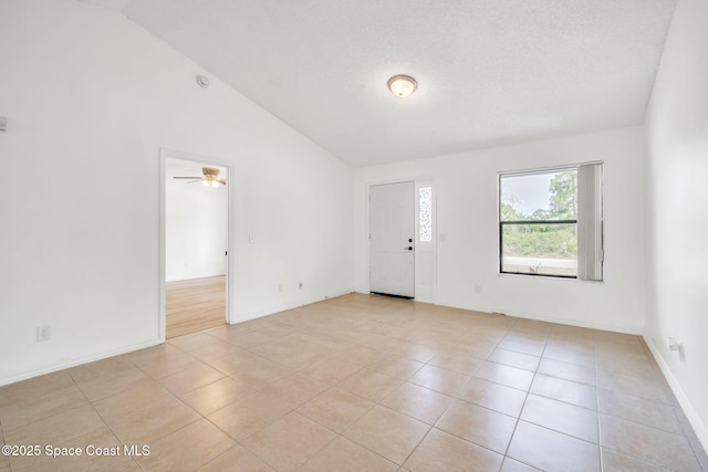 1680 Travis St SE, Palm Bay, FL 32909 - empty room featuring light tile patterned flooring, lofted ceiling, baseboards, ceiling fan, and a textured ceiling