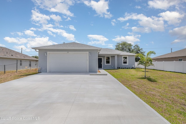 ranch-style home featuring an attached garage, driveway, fence, and a front yard