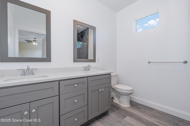 full bath featuring a sink, toilet, baseboards, and wood finished floors