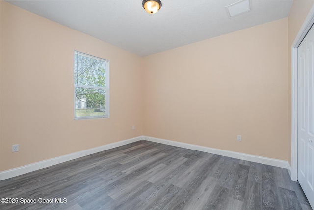 spare room with dark wood-type flooring, baseboards, and visible vents