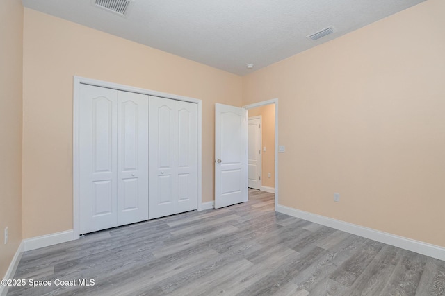 unfurnished bedroom featuring visible vents, wood finished floors, and baseboards