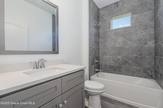 bathroom featuring vanity, toilet, shower / bathtub combination, and wood finished floors