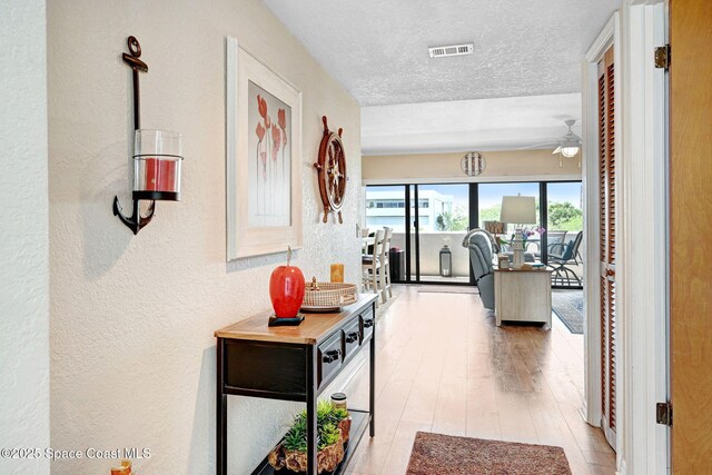 5011 Dixie Hwy NE Unit A312, Palm Bay, FL 32905 - hall featuring a textured wall, wood finished floors, and a textured ceiling