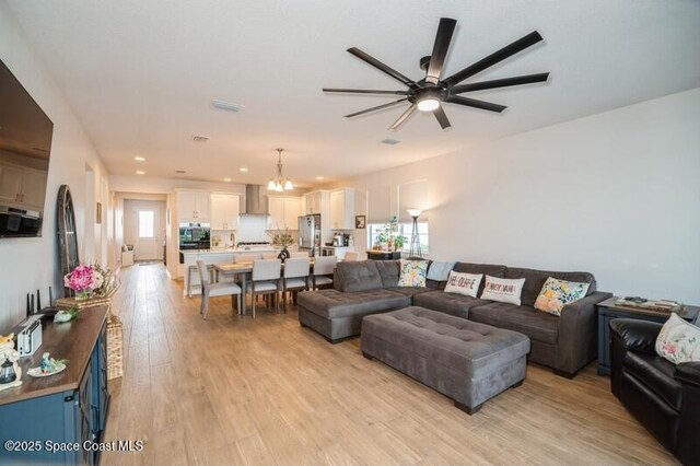 2979 Pangea Cir, Melbourne, FL 32940 - living area featuring a ceiling fan, a chandelier, light wood-type flooring, and recessed lighting