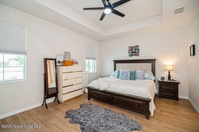 2979 Pangea Cir, Melbourne, FL 32940 - bedroom with light wood-type flooring, a raised ceiling, baseboards, and a ceiling fan