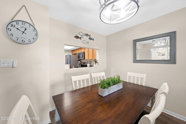dining space featuring baseboards and dark wood-style floors