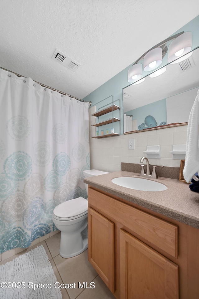 bathroom featuring vanity, toilet, visible vents, and tile patterned flooring