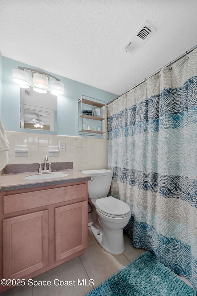 bathroom featuring tile walls, toilet, visible vents, tile patterned flooring, and vanity