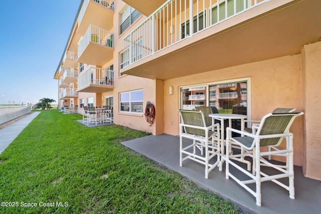 view of community with a patio and a lawn
