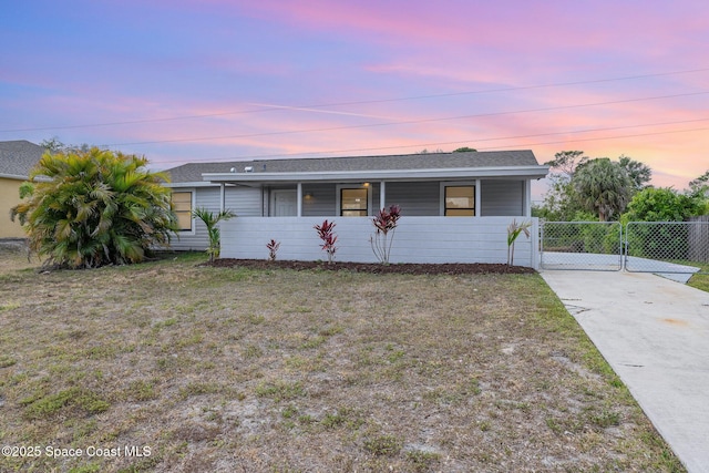 single story home with a porch, concrete driveway, a shingled roof, and a gate