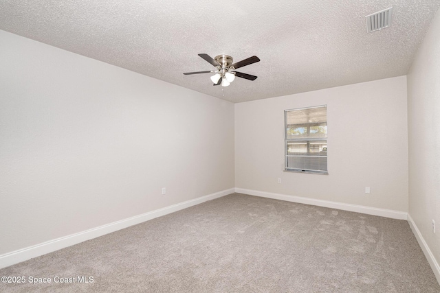 unfurnished room with a ceiling fan, carpet flooring, baseboards, and a textured ceiling