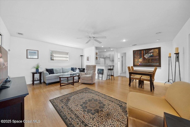 living room featuring ceiling fan, recessed lighting, visible vents, and light wood-style floors