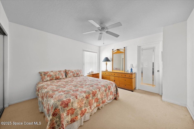 carpeted bedroom featuring ceiling fan, a textured ceiling, and baseboards