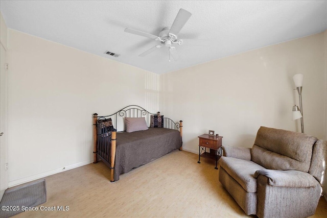 bedroom with light wood-type flooring, baseboards, visible vents, and a ceiling fan