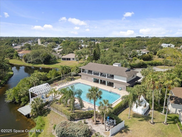 pool featuring a water view, a patio, and fence