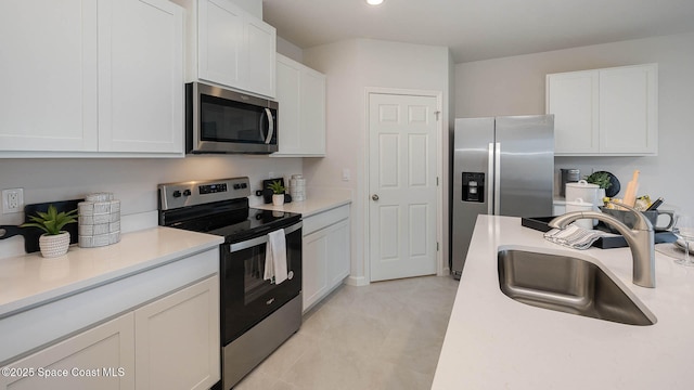 kitchen featuring white cabinetry, light countertops, stainless steel appliances, and a sink