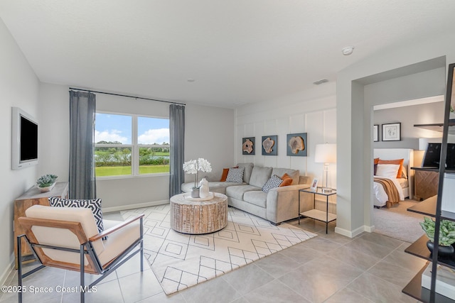 living area with baseboards, light tile patterned floors, and visible vents