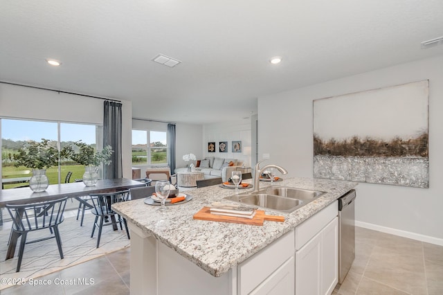 kitchen featuring stainless steel dishwasher, visible vents, a sink, white cabinetry, and an island with sink