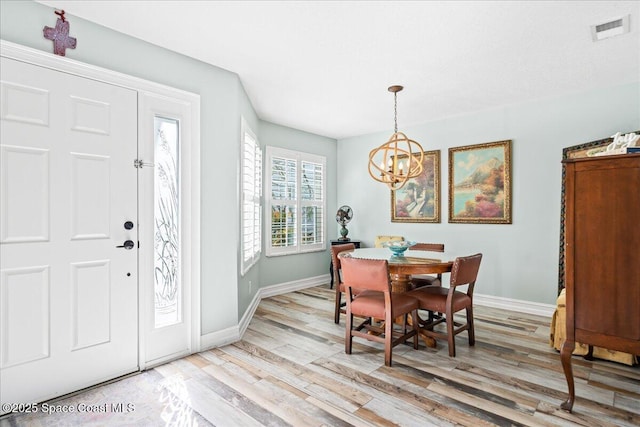 505 Tradewinds Dr, Indian Harbour Beach, FL 32937 - dining room with baseboards, an inviting chandelier, light wood-style flooring, and visible vents