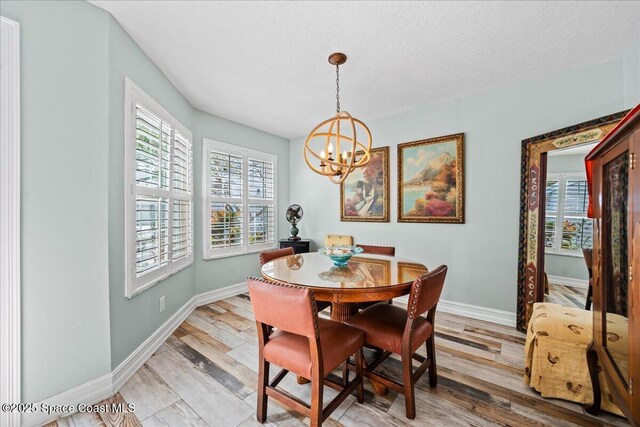 505 Tradewinds Dr, Indian Harbour Beach, FL 32937 - dining area featuring a chandelier, baseboards, and light wood-type flooring