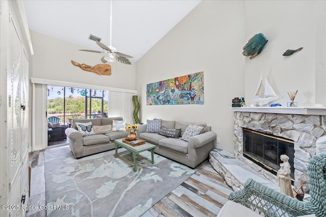 505 Tradewinds Dr, Indian Harbour Beach, FL 32937 - living room featuring wood finished floors, high vaulted ceiling, visible vents, a stone fireplace, and ceiling fan