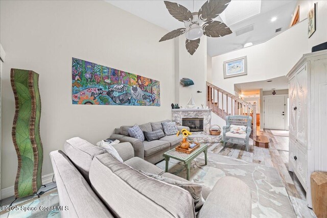 505 Tradewinds Dr, Indian Harbour Beach, FL 32937 - living room with a ceiling fan, baseboards, visible vents, a towering ceiling, and a fireplace