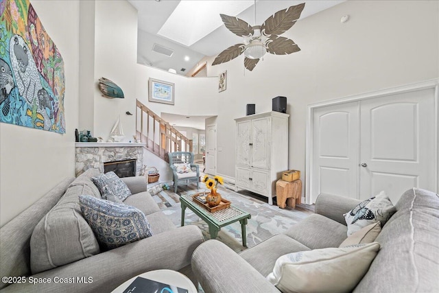 505 Tradewinds Dr, Indian Harbour Beach, FL 32937 - living room with a ceiling fan, baseboards, a stone fireplace, visible vents, and high vaulted ceiling
