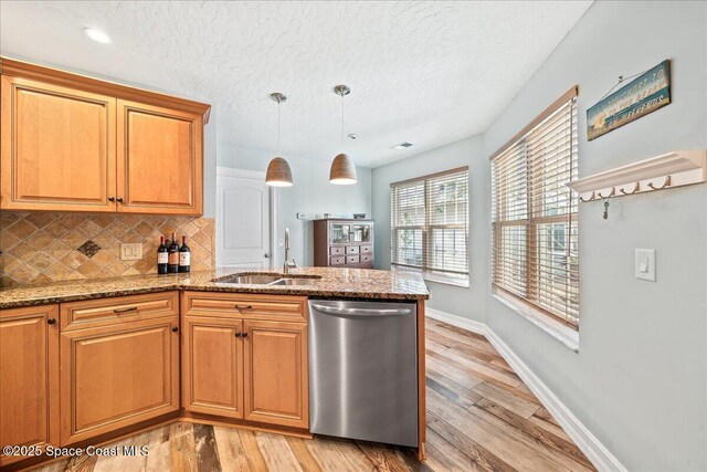 505 Tradewinds Dr, Indian Harbour Beach, FL 32937 - kitchen with light wood-style flooring, dishwasher, a sink, a peninsula, and tasteful backsplash
