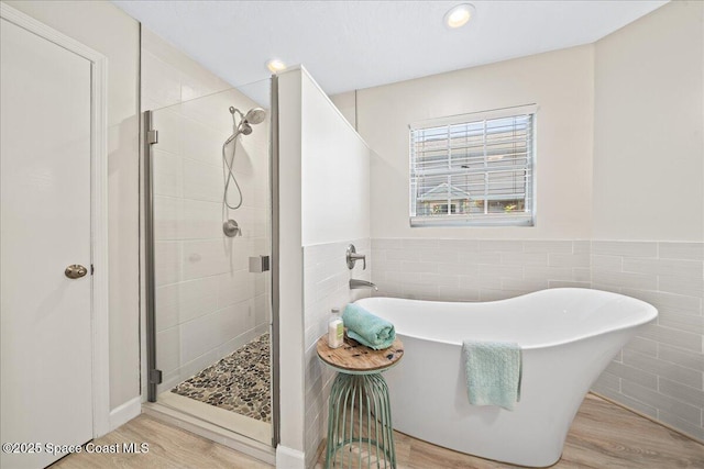 505 Tradewinds Dr, Indian Harbour Beach, FL 32937 - full bathroom featuring a stall shower, tile walls, and wood finished floors