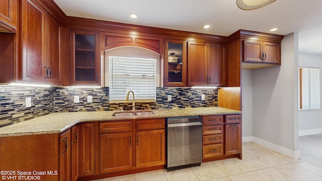 kitchen with dishwasher, a sink, baseboards, decorative backsplash, and glass insert cabinets