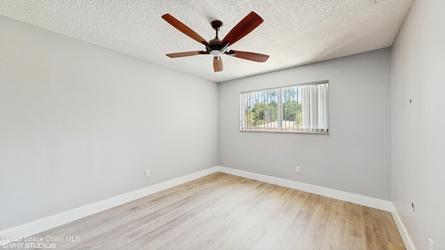 spare room featuring wood finished floors, a ceiling fan, baseboards, and a textured ceiling