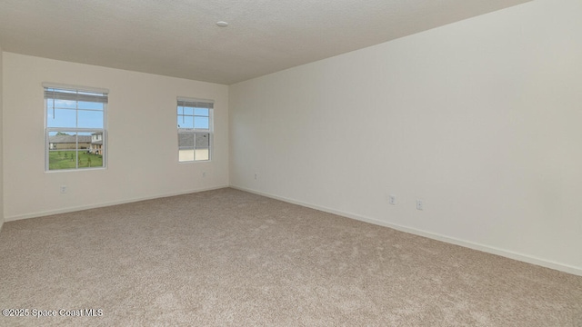 empty room with light colored carpet and baseboards