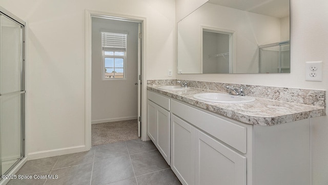 full bathroom with an enclosed shower, tile patterned floors, double vanity, and a sink