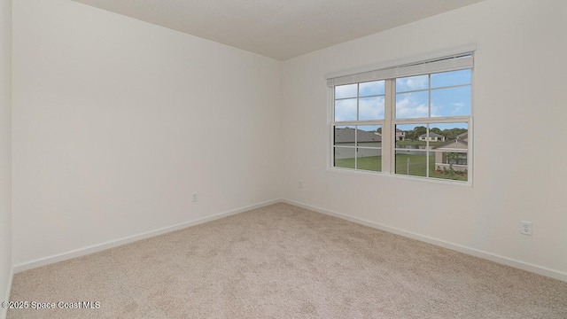 carpeted spare room with baseboards