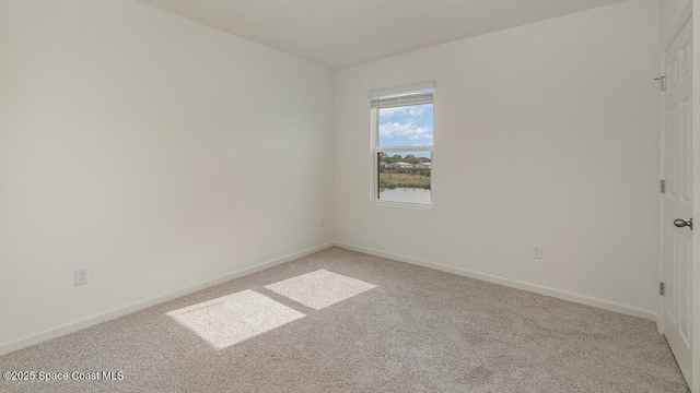 unfurnished room featuring baseboards and light colored carpet