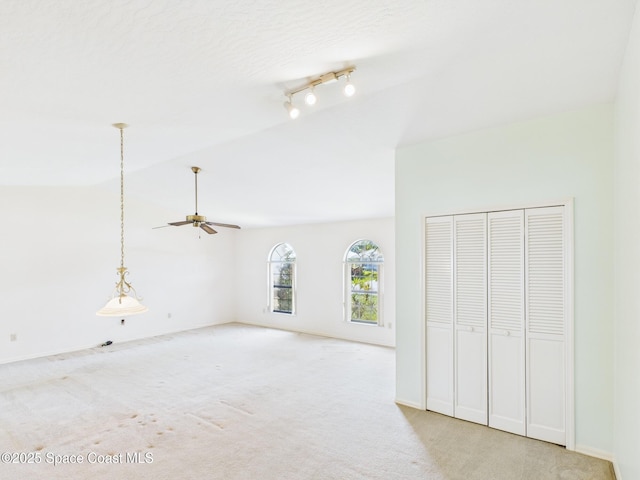 unfurnished bedroom with lofted ceiling, light carpet, and baseboards