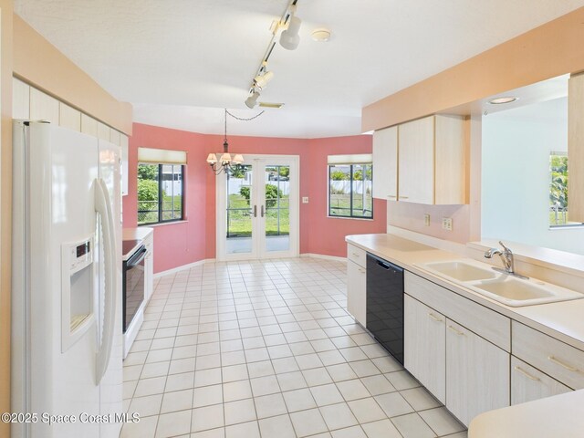kitchen featuring baseboards, white refrigerator with ice dispenser, a sink, and dishwasher