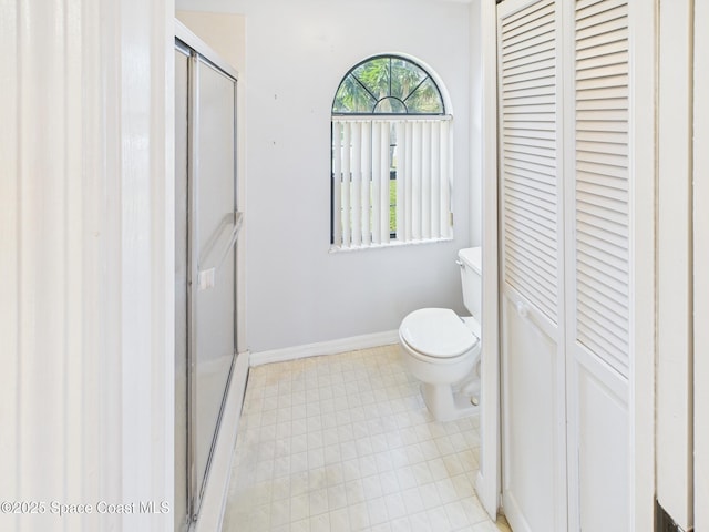 full bath featuring a shower stall, baseboards, a closet, and toilet