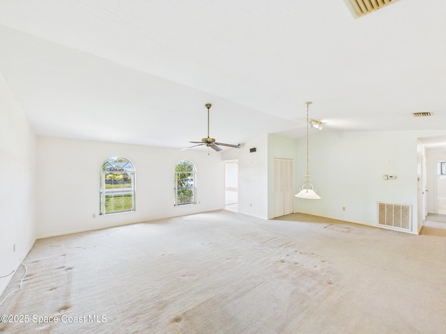 unfurnished living room featuring light colored carpet, baseboards, ceiling fan, and visible vents
