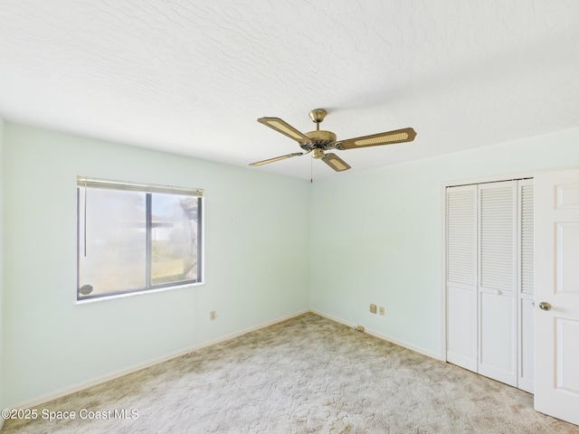 unfurnished bedroom with a closet, baseboards, ceiling fan, and carpet floors