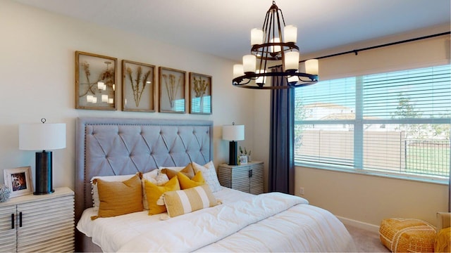 bedroom featuring a chandelier, carpet floors, and baseboards