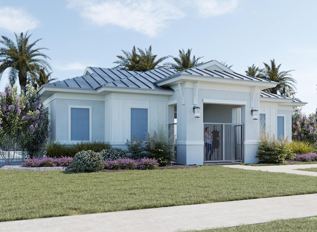 view of front facade featuring a gate, stucco siding, a front yard, metal roof, and a standing seam roof
