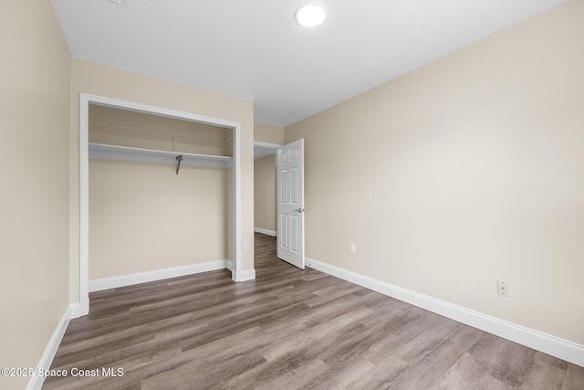 619 Dinner St NE, Palm Bay, FL 32907 - unfurnished bedroom featuring a closet, wood finished floors, and baseboards