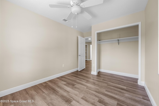619 Dinner St NE, Palm Bay, FL 32907 - unfurnished bedroom featuring wood finished floors, a ceiling fan, a closet, visible vents, and baseboards