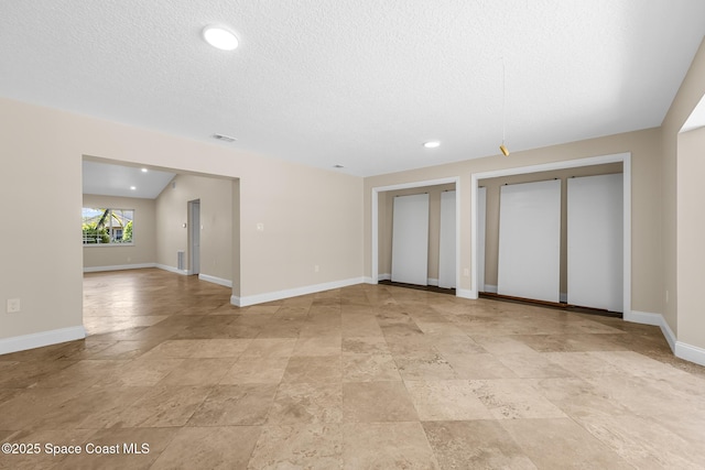 619 Dinner St NE, Palm Bay, FL 32907 - unfurnished living room with a textured ceiling, visible vents, baseboards, and recessed lighting