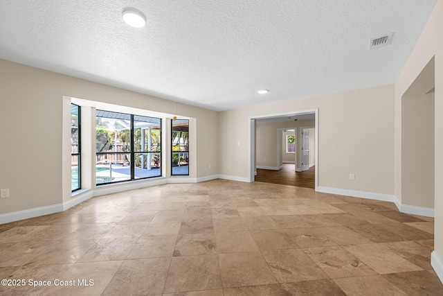 619 Dinner St NE, Palm Bay, FL 32907 - spare room with stone finish flooring, a textured ceiling, baseboards, and visible vents
