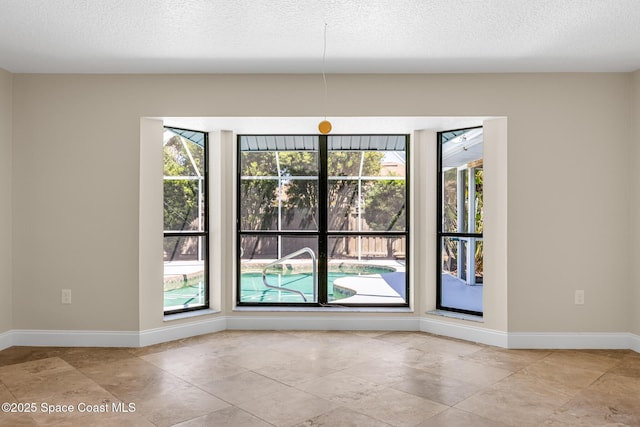 619 Dinner St NE, Palm Bay, FL 32907 - unfurnished dining area with a textured ceiling and baseboards