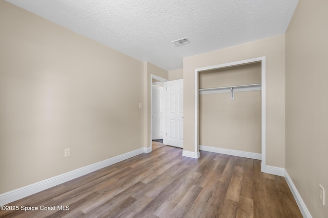 619 Dinner St NE, Palm Bay, FL 32907 - unfurnished bedroom with baseboards, a closet, visible vents, and wood finished floors