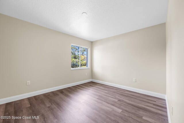619 Dinner St NE, Palm Bay, FL 32907 - spare room with a textured ceiling, baseboards, and wood finished floors