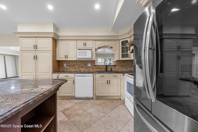619 Dinner St NE, Palm Bay, FL 32907 - kitchen featuring a sink, dark stone counters, white appliances, cream cabinetry, and backsplash